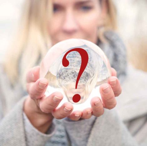 closeup of woman holding a glass ball with a question mark